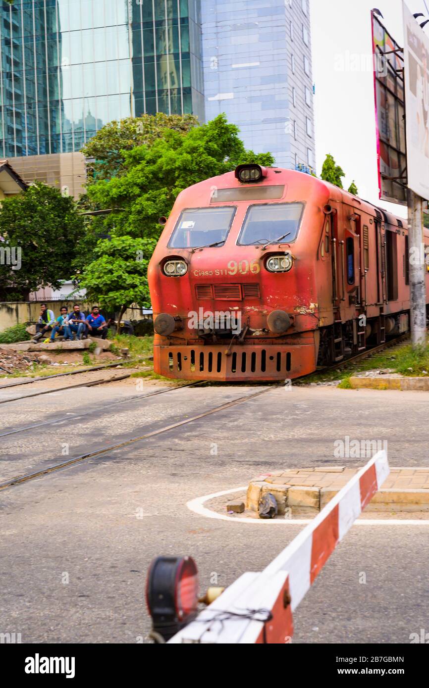 Asia meridionale Sri Lanka capitale Colombo Kompannavidiya Stazione livello attraversamento motore locomotiva binari alti edifici grattacieli Foto Stock