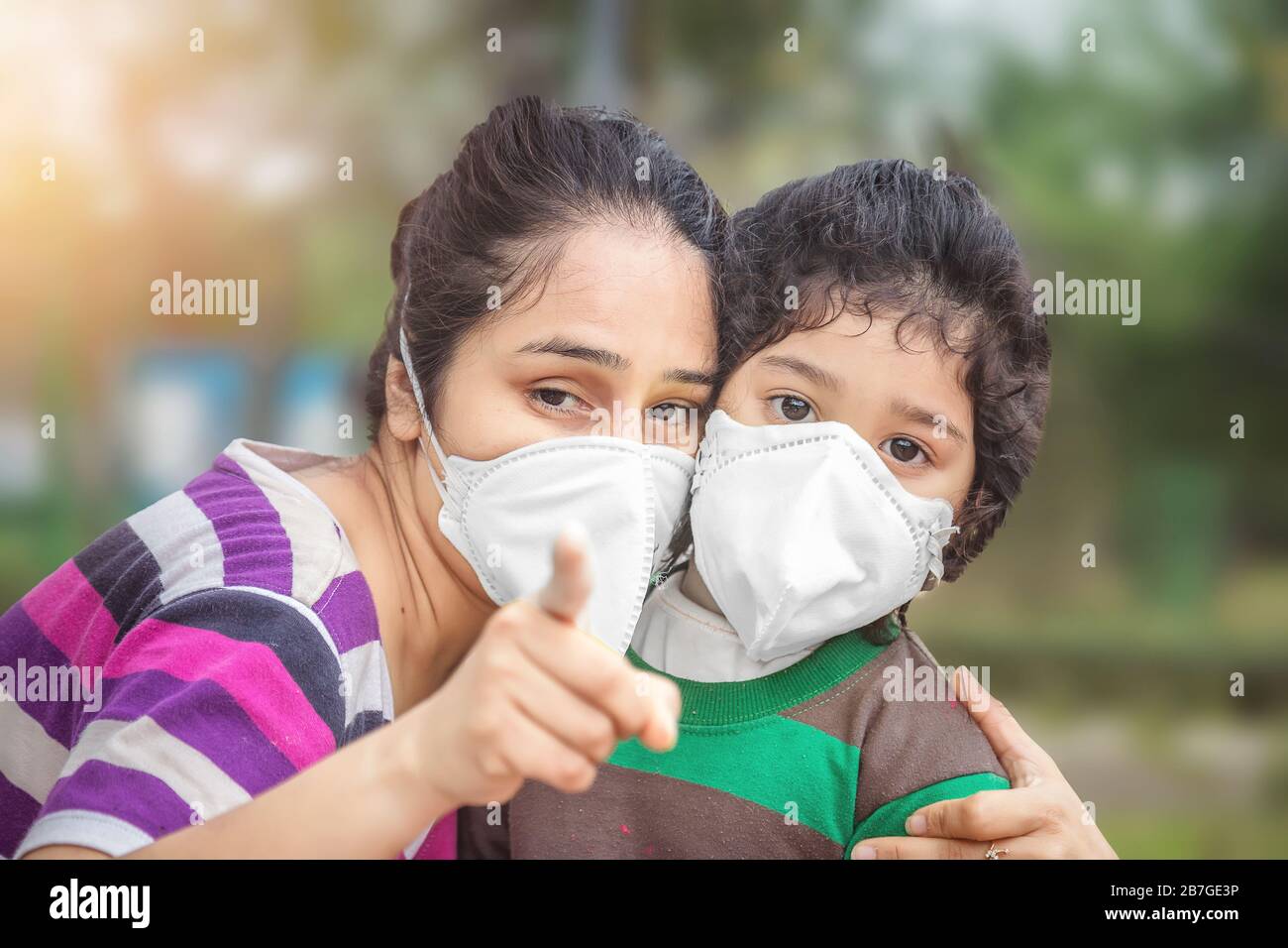 Covid-19 concetto di Coronavirus e inquinamento atmosferico pm2.5. Bambina indiana e madre che indossano maschera in pubblico affollato luogo per proteggere e per fermare Foto Stock