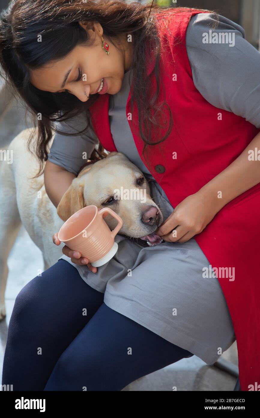 Donna che alimenta i biscotti del cane al suo animale domestico. Foto Stock