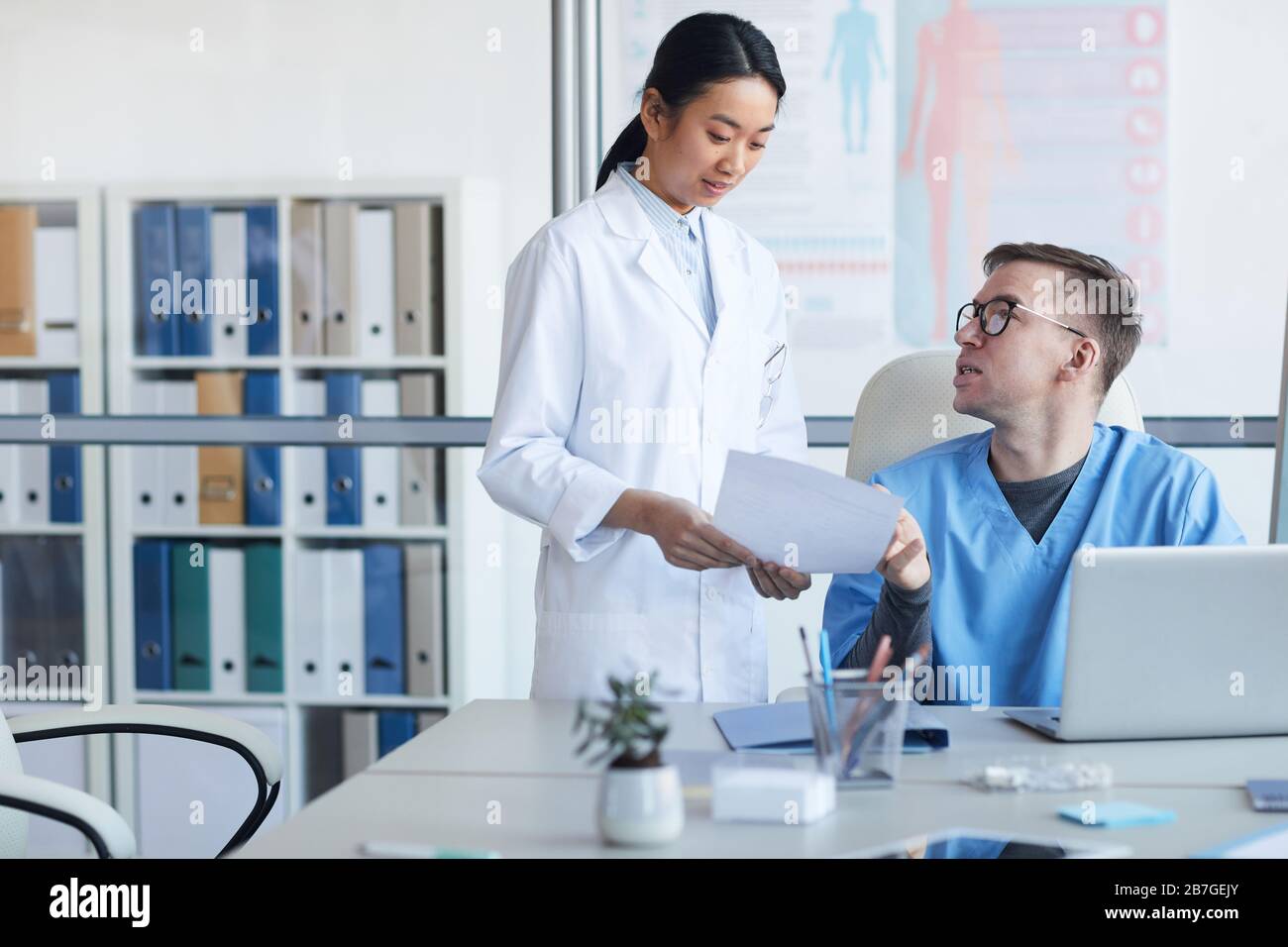 Ritratto di giovane medico asiatico consulente supervisore durante internship in clinica, copia spazio Foto Stock