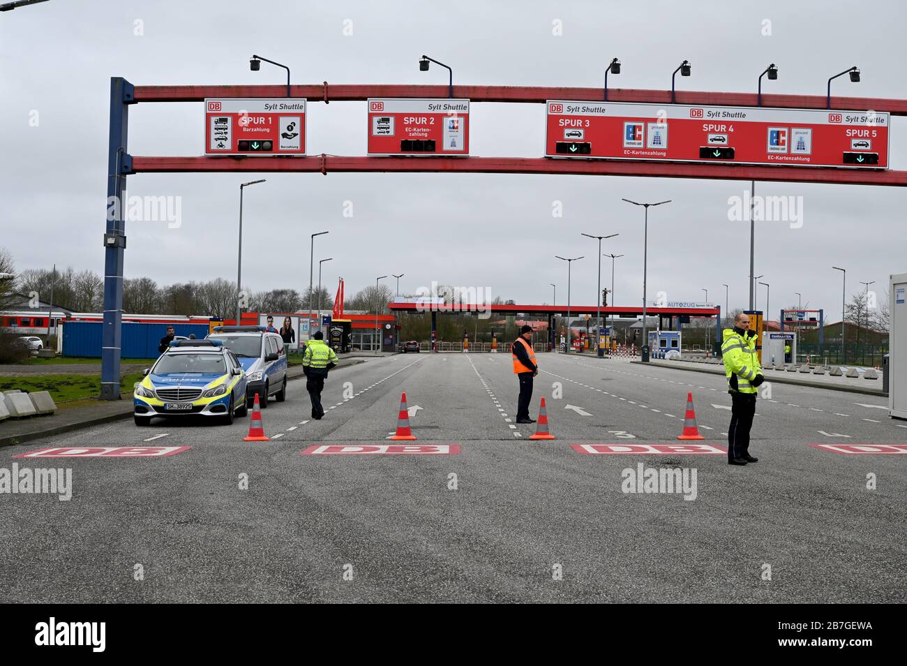 16 marzo 2020, Schlewig-Holstein, Niebüll: I poliziotti sono in piedi all'ingresso della stazione di carico di Sylt. A causa della diffusione del coronavirus, l'accesso alle isole è consentito solo ai residenti e ai pendolari. Foto: Carsten Rehder/dpa Foto Stock