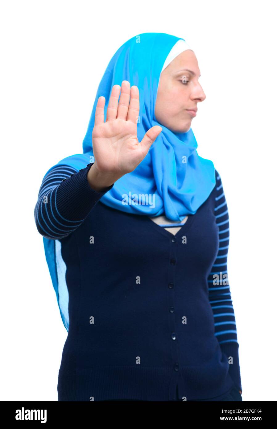 Primo piano ritratto di una giovane donna musulmana seria che mostra stop rifiuto gesto con la sua palma isolato su sfondo bianco Foto Stock