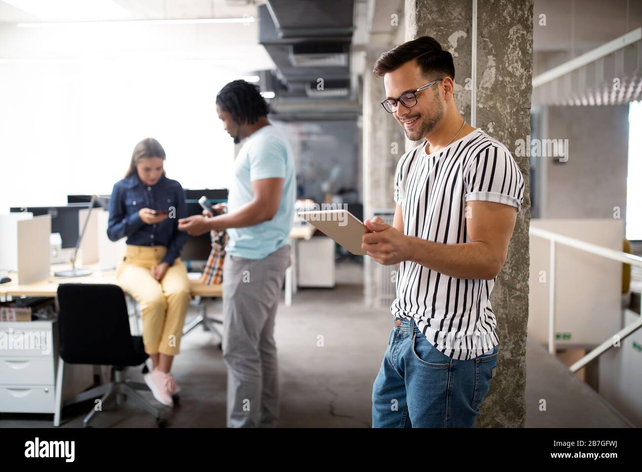 Giovane uomo utilizzando la tecnologia digitale compressa in corporate business office Foto Stock