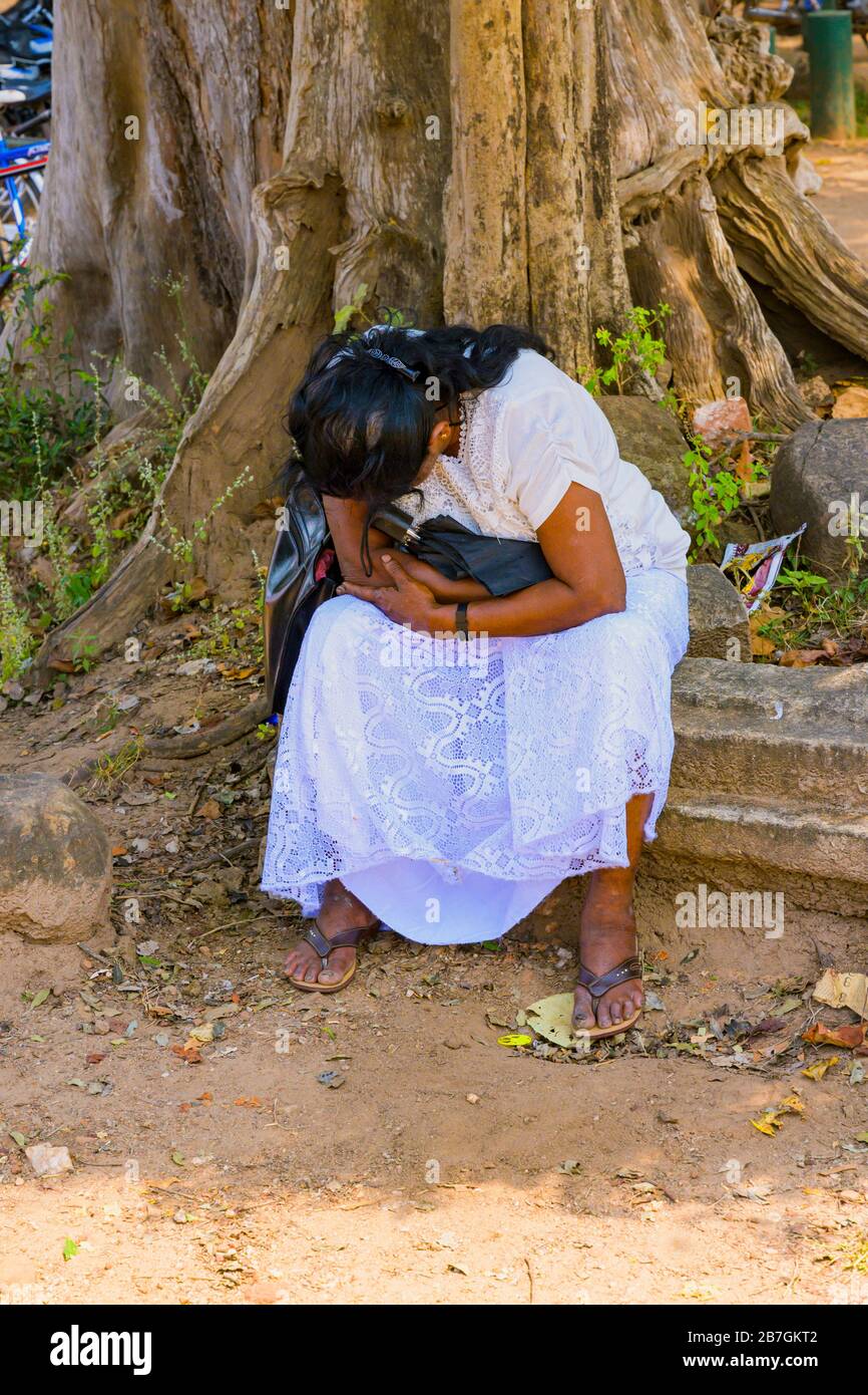 Asia Sri Lanka Polonnaruwa il Quadrangle Palace of King Parakramabahu locale femmina turistico naps siesta ombra alberi gradini scale stipare ombrellone Foto Stock