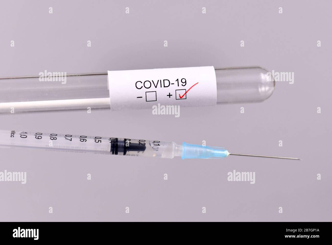 Siringa e provetta per test medici per Coronavirus con etichetta Covid-19 in background sfocato, concetto per il trattamento o lo sviluppo della vaccinazione Foto Stock