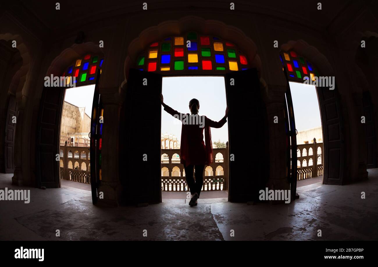 Donna con sciarpa in silhouette in piedi in arco con mosaico di vetro di Hawa Mahal, Rajasthan, India Foto Stock