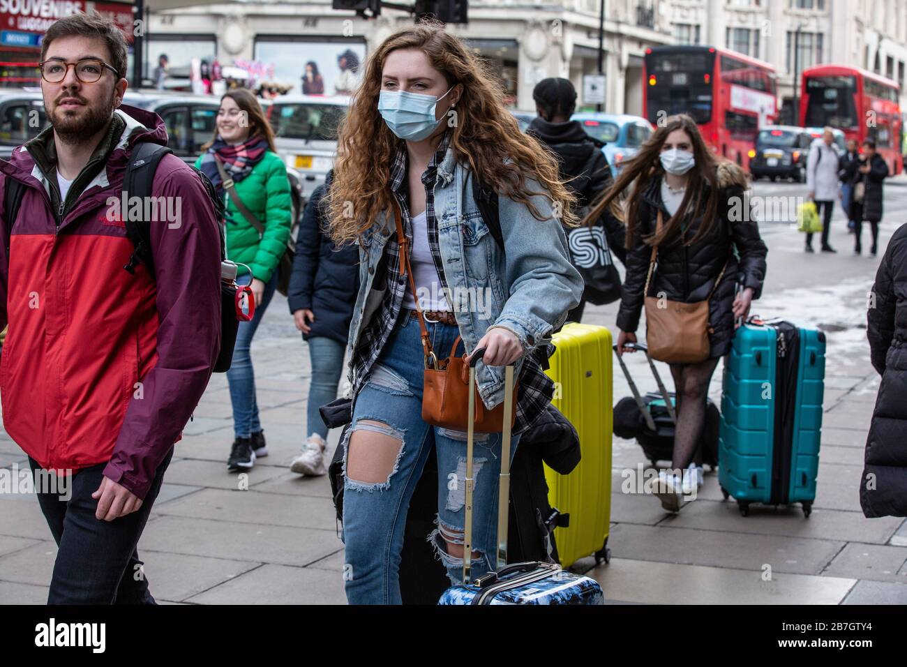 I viaggiatori prendono precauzioni indossando maschere facciali nel West End di Londra contro l'infezione della pandemia Coronavirus Covid19, Inghilterra, Regno Unito Foto Stock