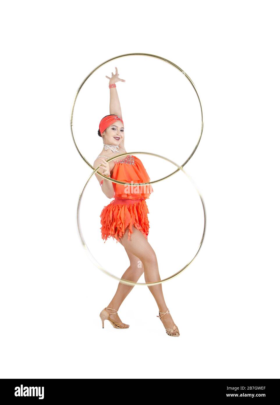 Una donna in un abito da palcoscenico esegue una danza con un hula Hoop. Riprese in studio su sfondo bianco. Foto Stock