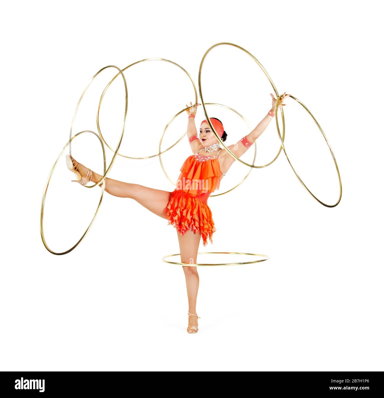 Una donna in un abito da palcoscenico esegue una danza con un hula Hoop. Riprese in studio su sfondo bianco. Foto Stock