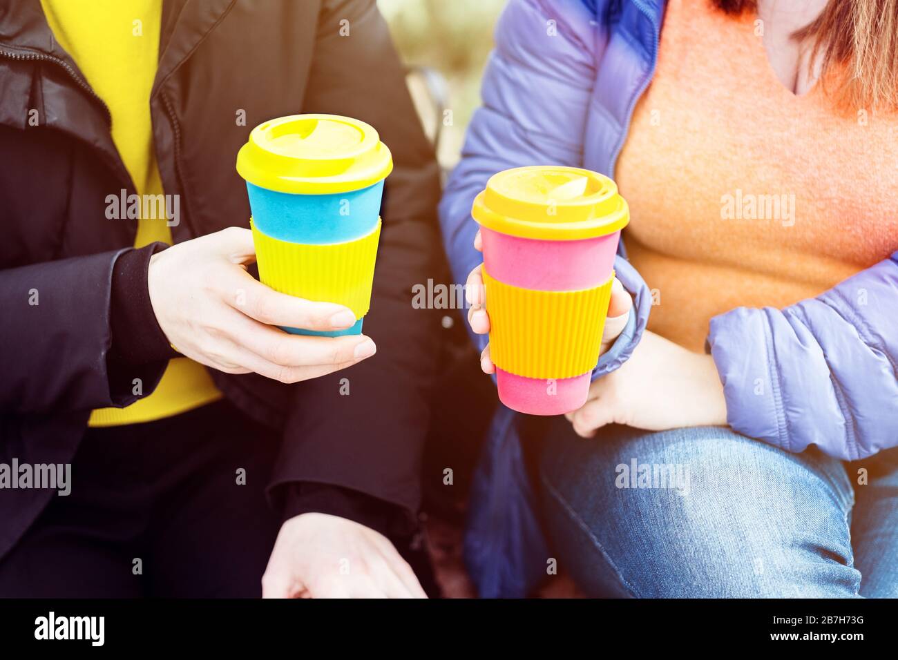 Due donne con tazza di caffè riutilizzabile. Zero sprechi. Concetto di stile di vita sostenibile. Foto Stock