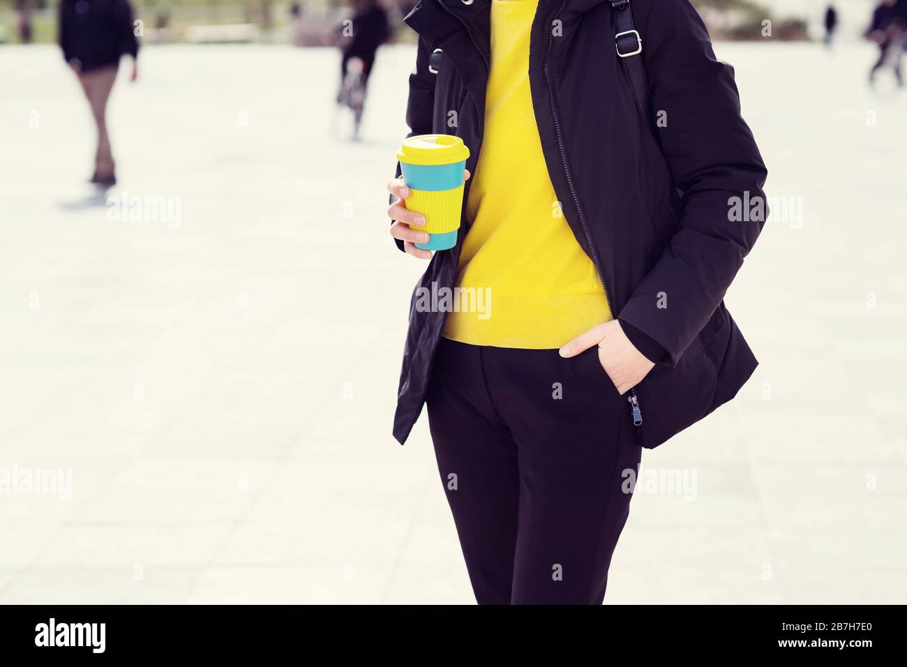 Le mani femminili trattengono una tazza di caffè riutilizzabile. Porta il tuo caffè sempre con te con una tazza riutilizzabile. Foto Stock