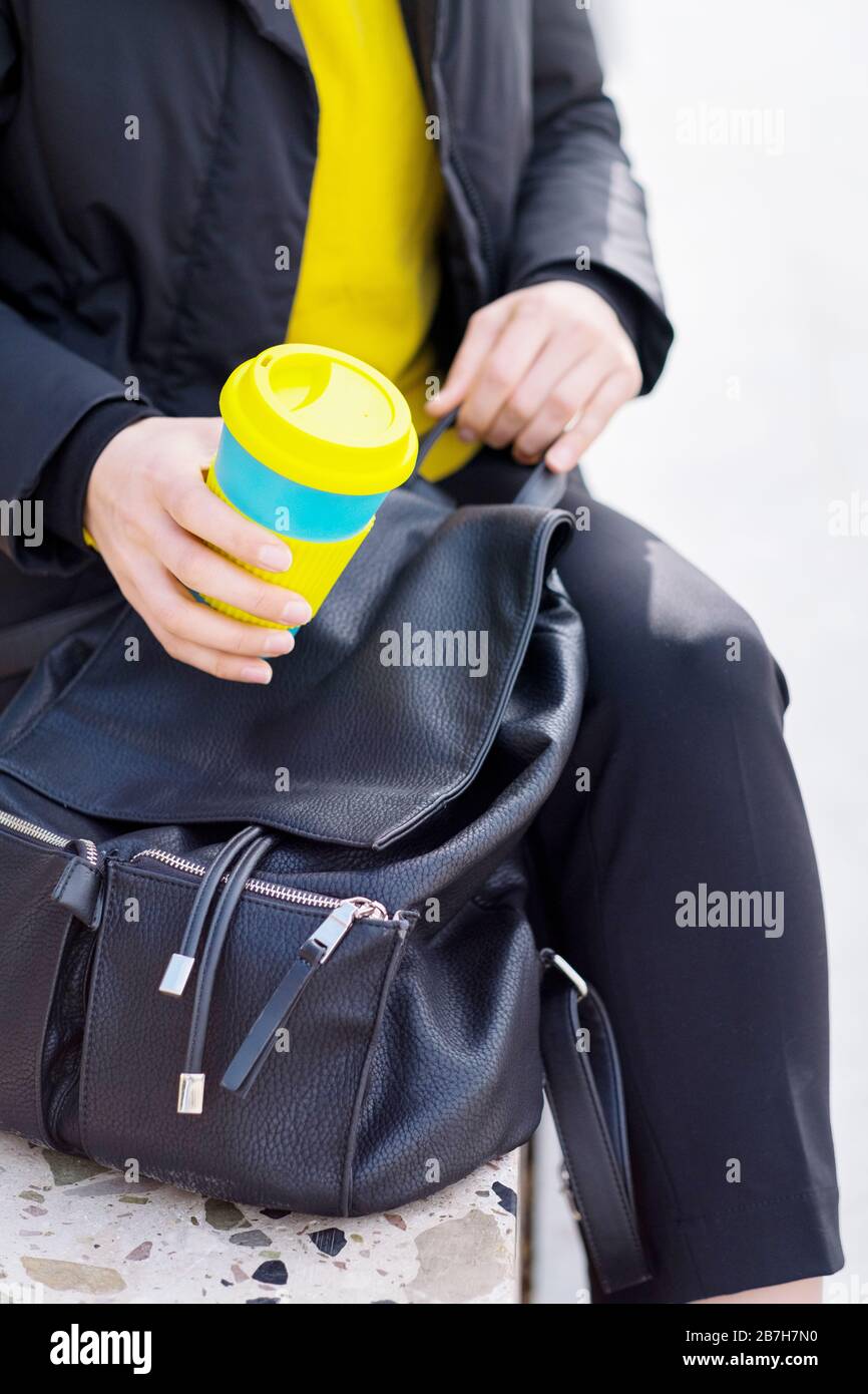 Le mani femminili trattengono una tazza di caffè riutilizzabile. Porta il tuo caffè sempre con te con una tazza riutilizzabile. Foto Stock