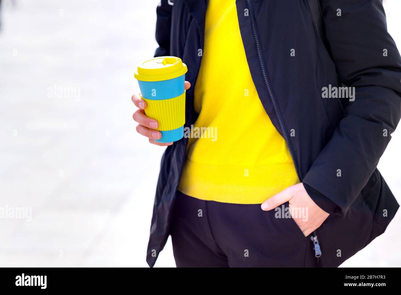 Le mani femminili trattengono una tazza di caffè riutilizzabile. Porta il tuo caffè sempre con te con una tazza riutilizzabile. Foto Stock