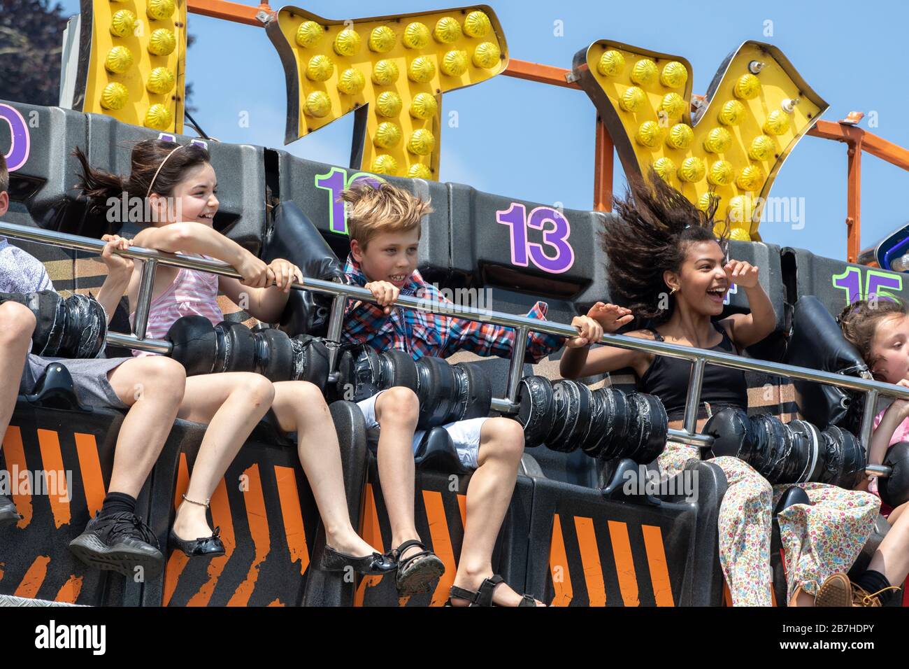 I capelli volanti delle ragazze adolescenti su un divertente giro in fiera Foto Stock