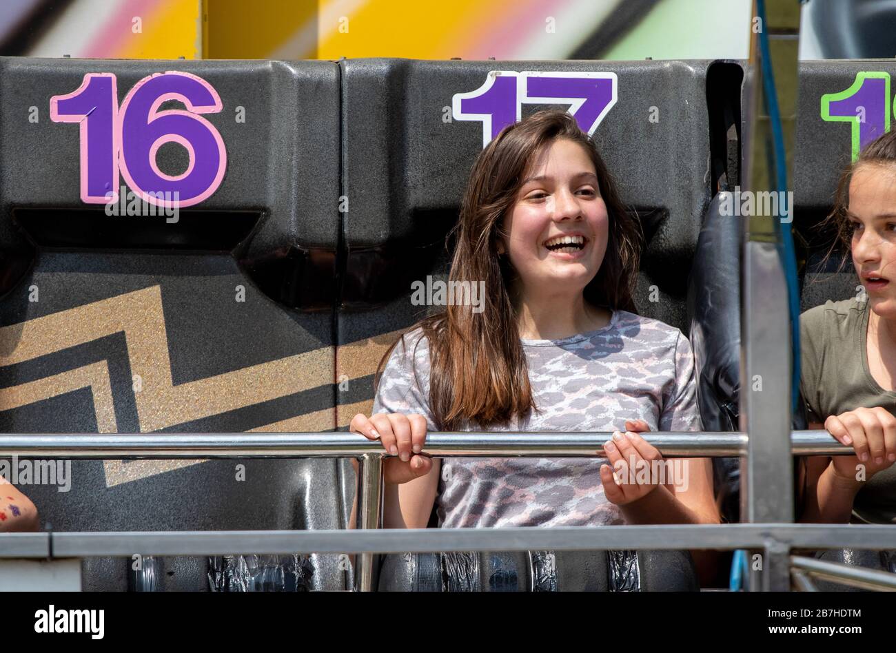 I capelli volanti delle ragazze adolescenti su un divertente giro in fiera Foto Stock