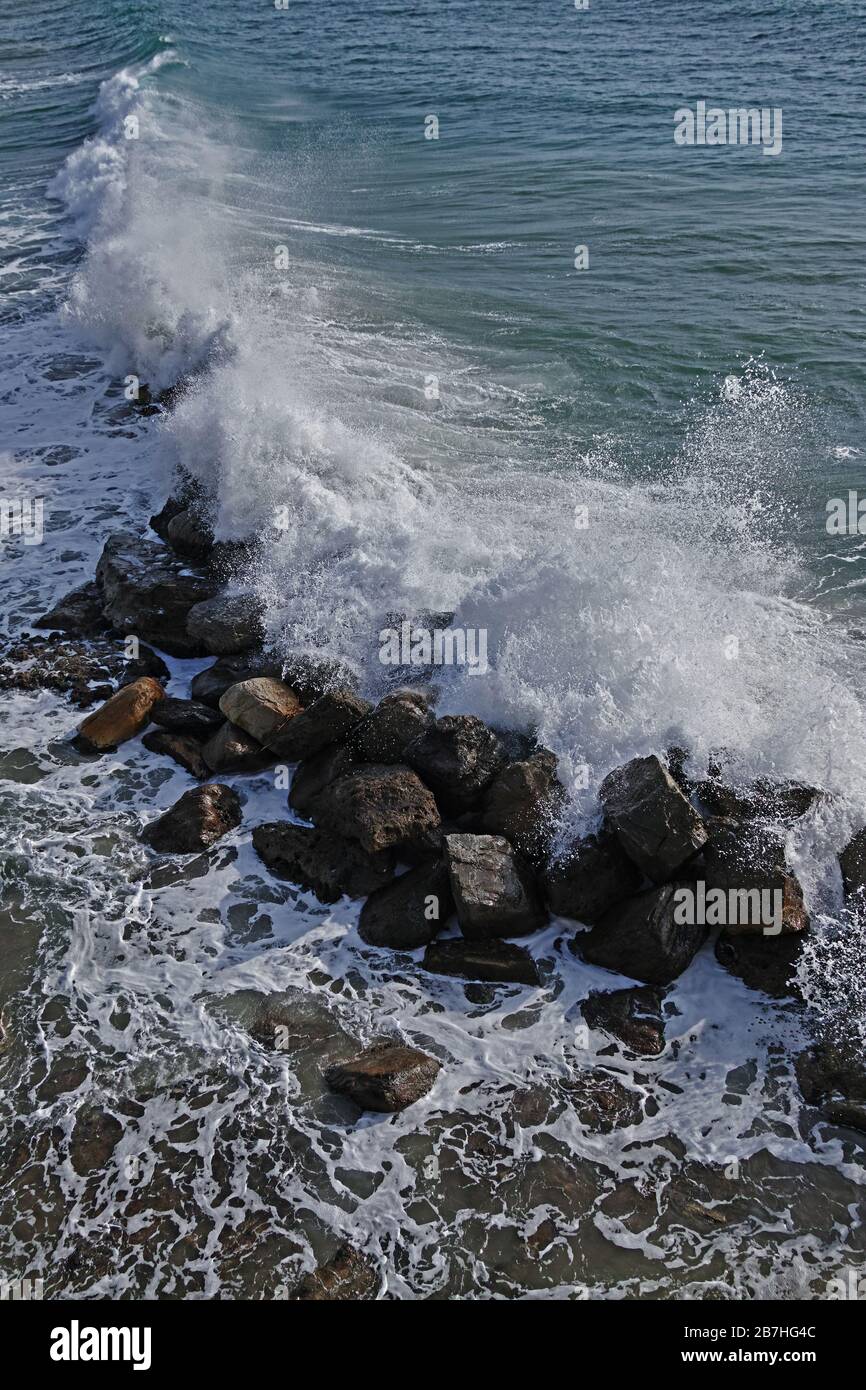 l'onda si schianta sui massi di una frangiflutti Foto Stock