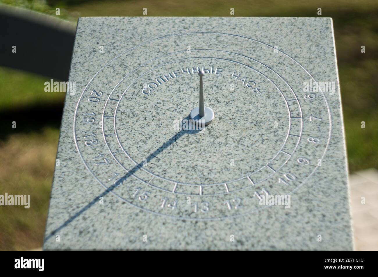 Meridiana su una strada della città. L'iscrizione in russo su una pietra è un orologio solare Foto Stock