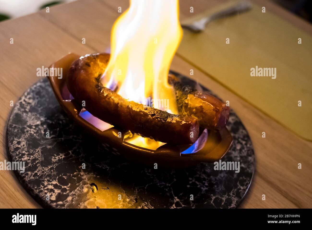 chouriço un Bombeiro (salsiccia portoghese alla griglia) grigliato su un piccolo recipiente di cottura in argilla chiamato Assador de Barro Foto Stock
