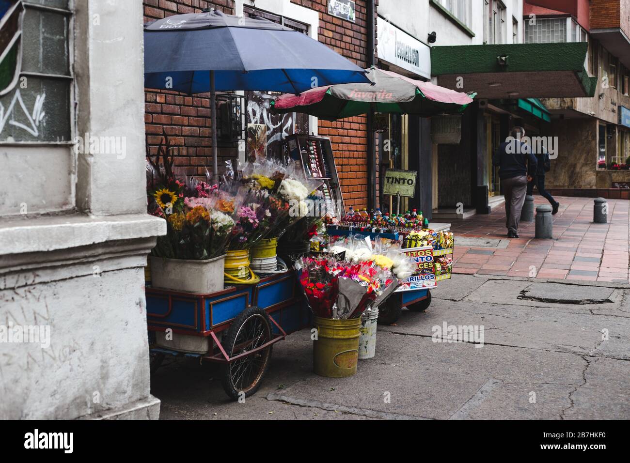 Scene di strada nel barrio Chapinero di Bogotà; una piccola stalla che vende fiori da carretto a passerby Foto Stock