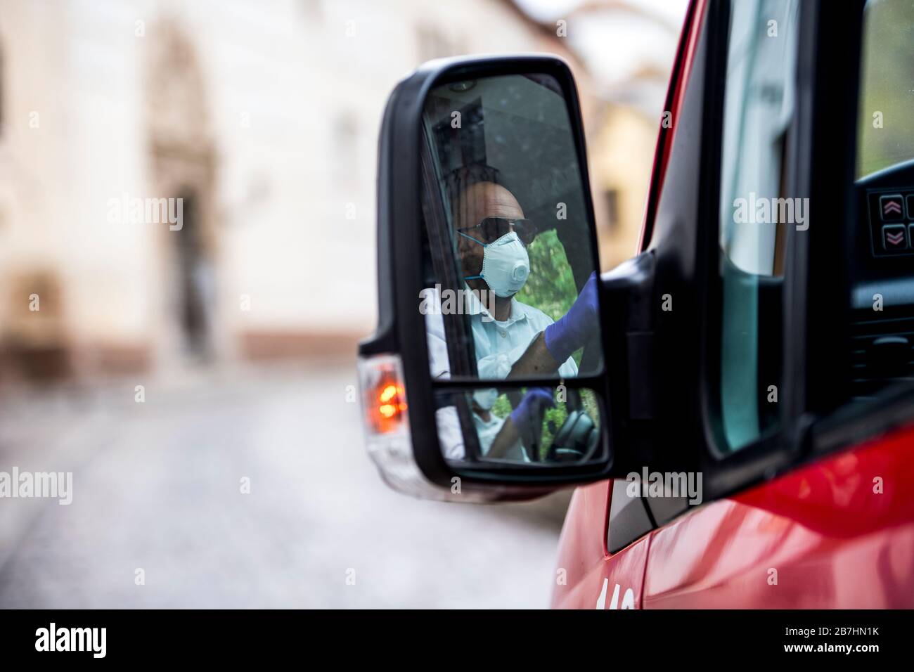 Un conducente di autobus che indossa una maschera facciale come precauzione contro la diffusione di Coronavirus si riflette in un bus mirror.in Granada ci sono più di 80 casi positivi di diffusione del virus Covid-19 e due pazienti infetti sono morti. La Spagna ha più di 9000 casi di infezione con Covid-19 e più di 300 morti. Foto Stock