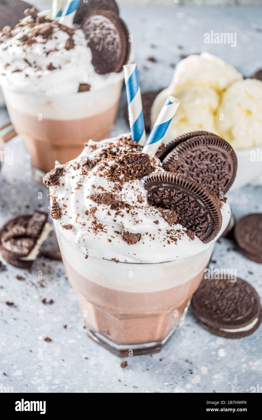 Moka al caffè con biscotti e panna. Gelato e biscotti al cioccolato dolce latte cocktail. Su tavolo in cemento grigio, con cucchiaio e tazza di furgone Foto Stock