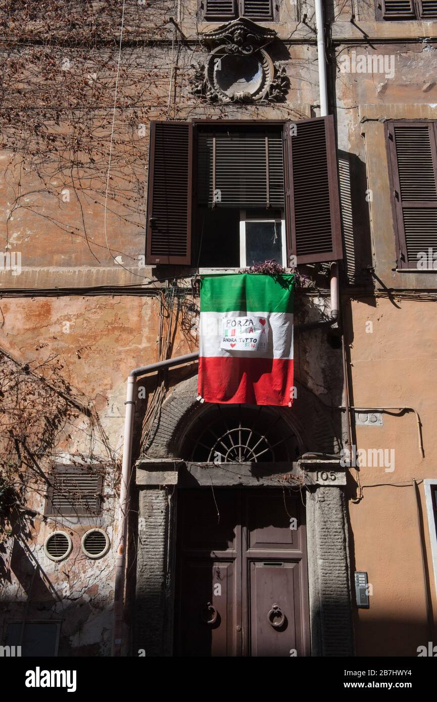 Roma al tempo del virus Corona. Bandiere tricolore e segnali di incoraggiamento dalle finestre di via Urbana. Foto Stock