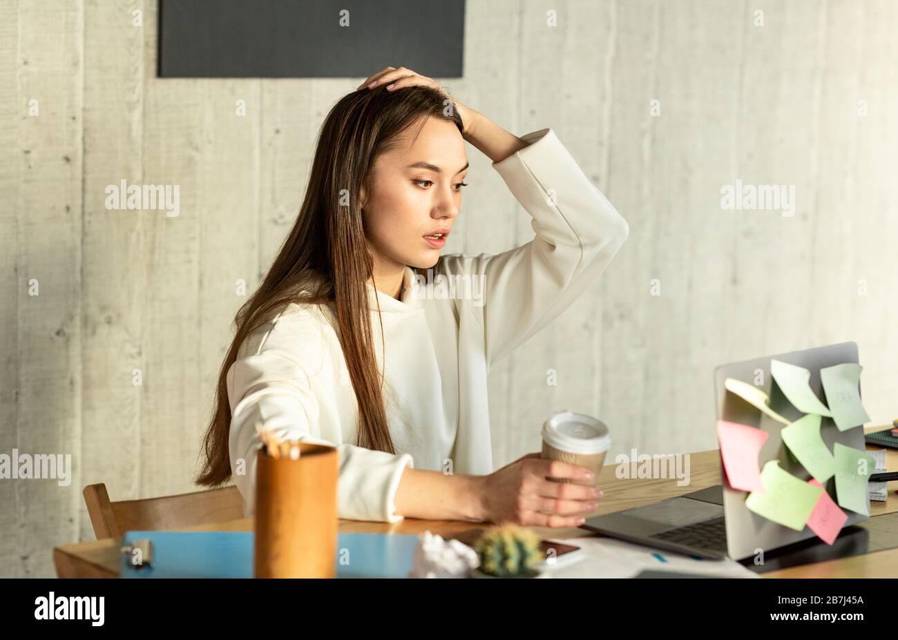 Donna freelance in shock e tenendo la testa Foto Stock