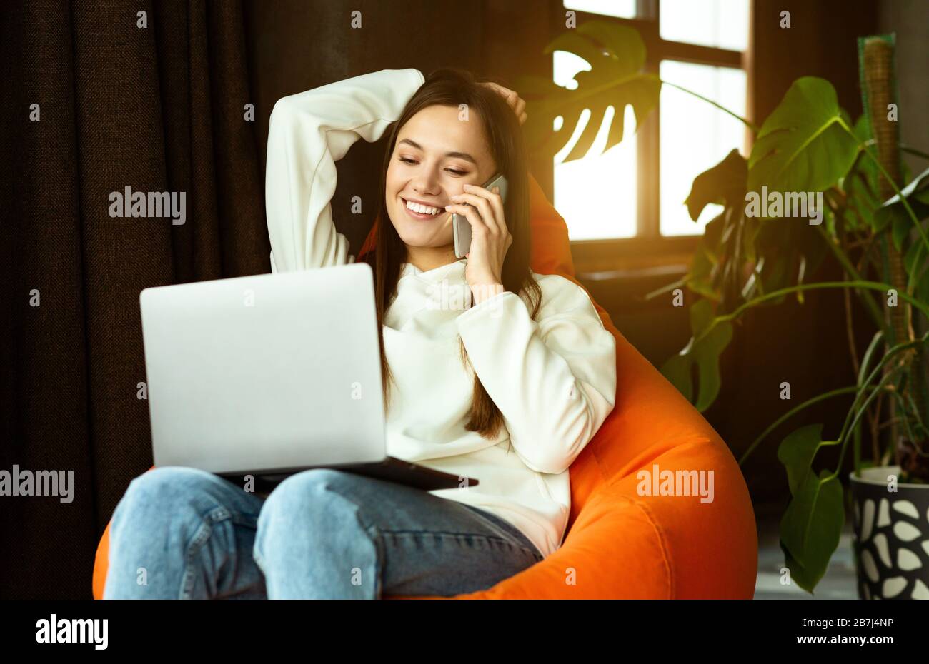 Lavoro freelance da qualsiasi luogo. Ragazza comunica sullo smartphone Foto Stock