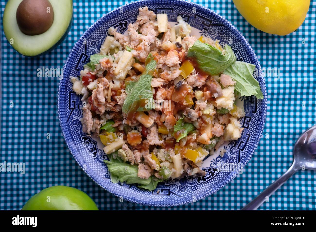 vista ad angolo alto dell'insalata e del tonno sul piatto con manubri sul tavolo Foto Stock