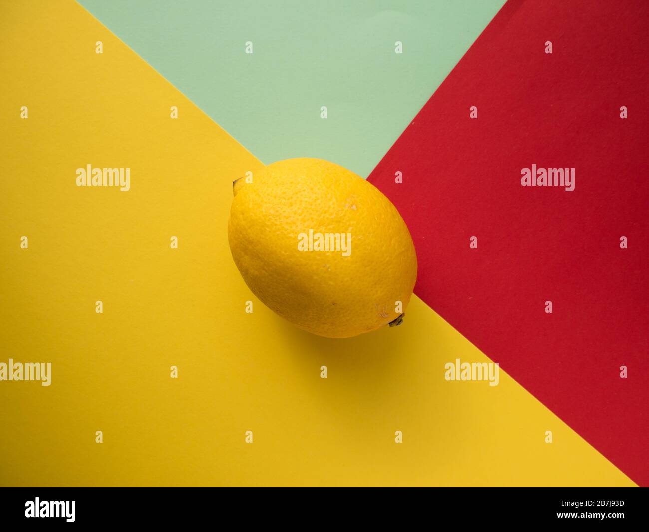 Limone su sfondo colorato, vista dall'alto. Foto colorata alla moda. Stile minimal con sfondo colorato di carta. Foto Stock