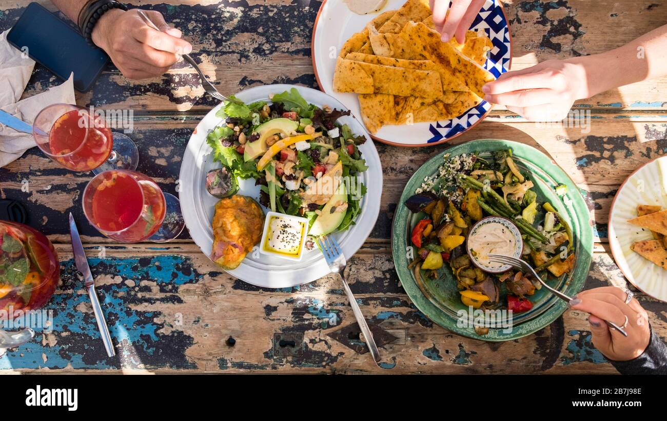 Vista su un piatto del pranzo vegetariano servito all'aperto su un tavolo da pranzo rustico Foto Stock