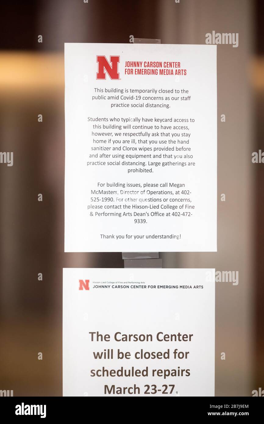 La carta attaccata a una porta di vetro delinea le misure adottate da un edificio dell'Università del Nebraska per tentare di mantenere la sicurezza pubblica. Foto Stock