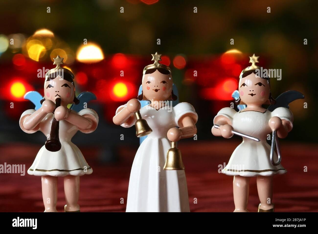 Concerto dell'Avvento: Tre angeli decorativi che fanno musica davanti alle luci della corona dell'Avvento Foto Stock