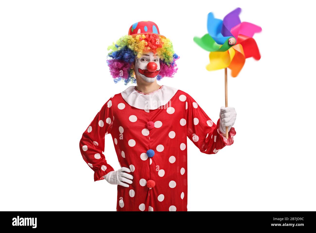 Clown che tiene una ruota girevole colorata isolata su sfondo bianco Foto Stock