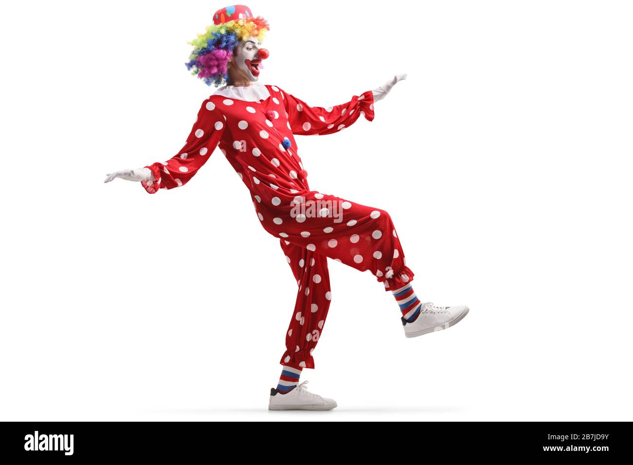 Scatto a tutta lunghezza di un clown in piedi su una gamba isolato su sfondo bianco Foto Stock