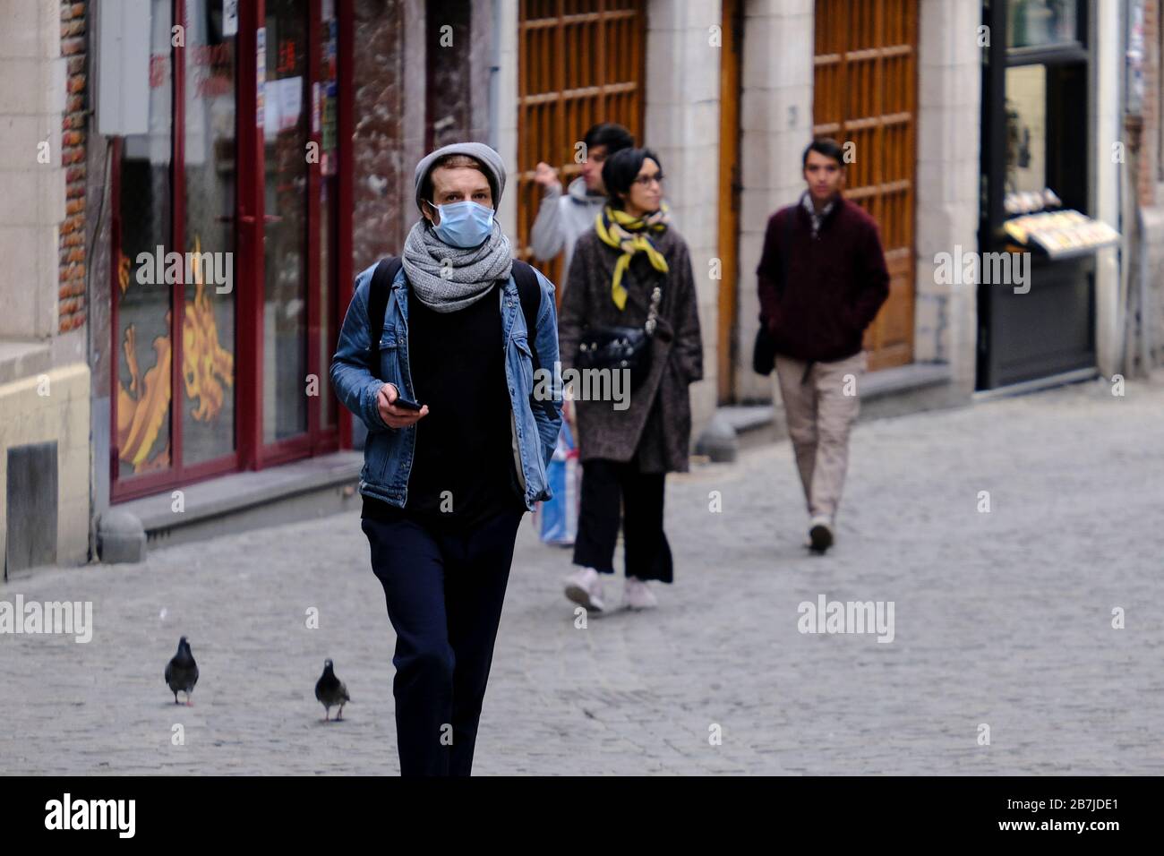 Bruxelles, Belgio. 16 Marzo 2020. Le persone che indossano maschere protettive per il viso in seguito allo scoppio del coronavirus si trovano nel centro storico di Bruxelles. Credit: ALEXANDROS MICHAILIDIS/Alamy Live News Foto Stock