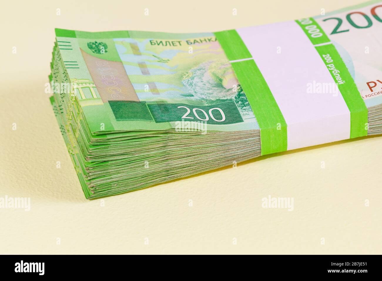 Il pacchetto di banconote di Dvuhmatchevyh nel pacchetto bancario si trova sul tavolo giallo. Investimento Foto Stock