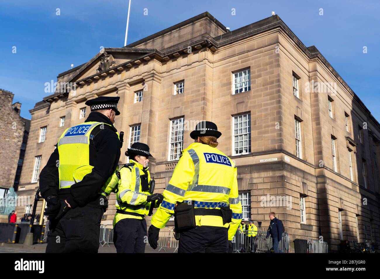 La polizia si trova al di fuori della High Court of Justiciary sul Royal Mile a Edimburgo, Scozia, Regno Unito Foto Stock