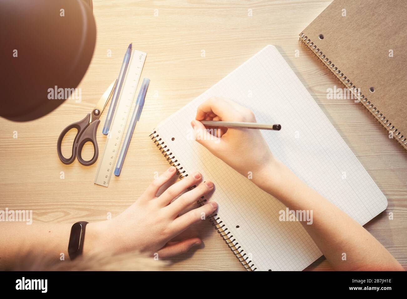 Vista dall'alto scrittura a mano su notebook. Concetto di istruzione. Mano con gli orologi intelligenti. Foto Stock