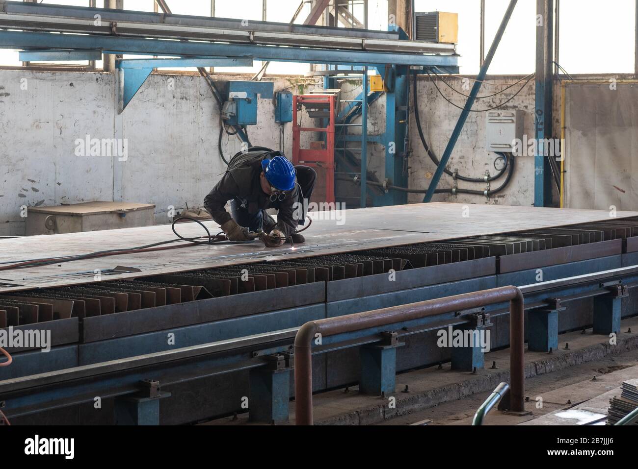 i lavoratori dei cantieri stanno lavorando nell'hangar per costruire una nuova nave Foto Stock