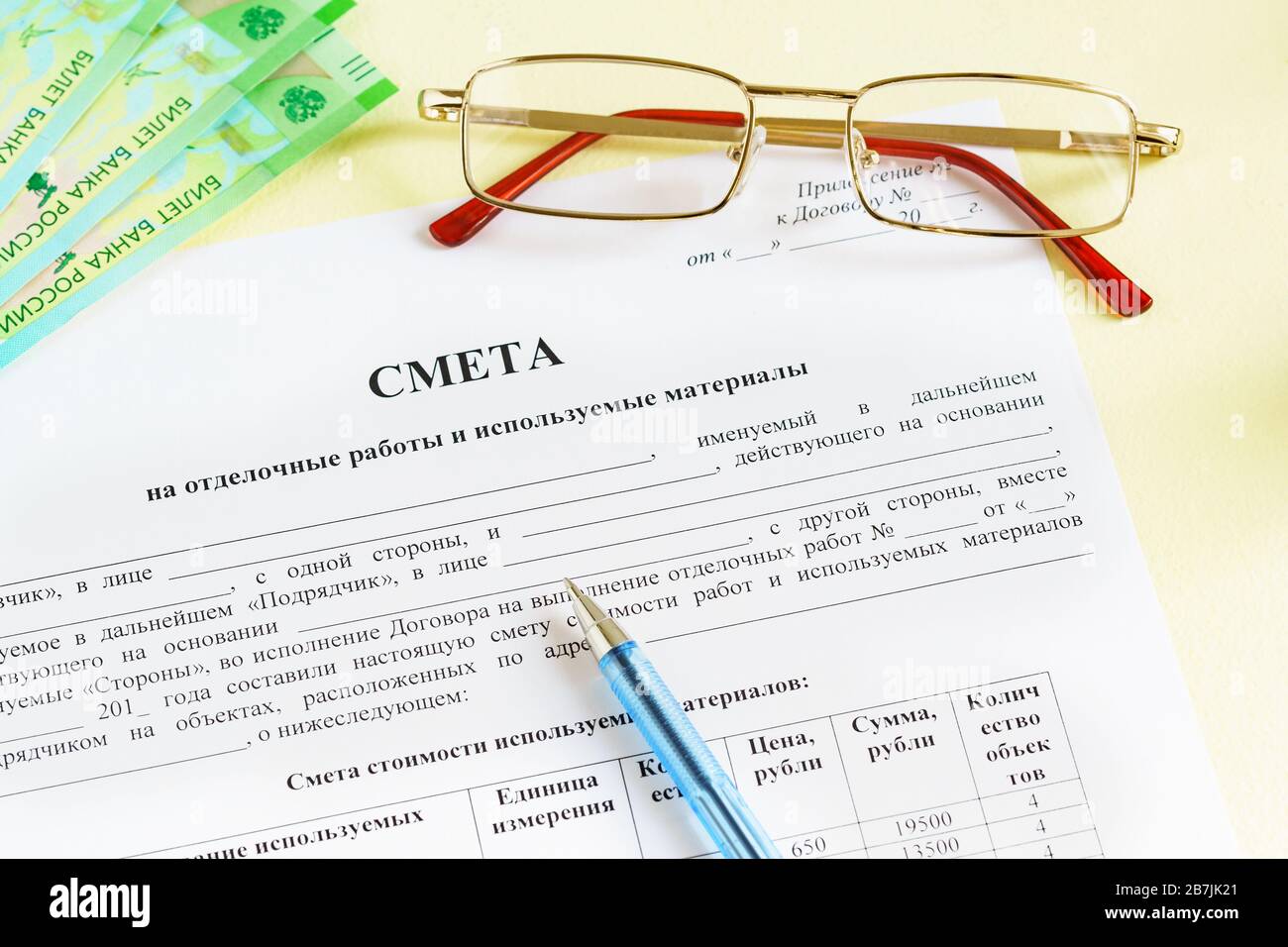 Documento in russo 'stime per lavori di finitura e materiali utilizzati ', occhiali, denaro e una penna sul tavolo. Tempo di pagamento Foto Stock