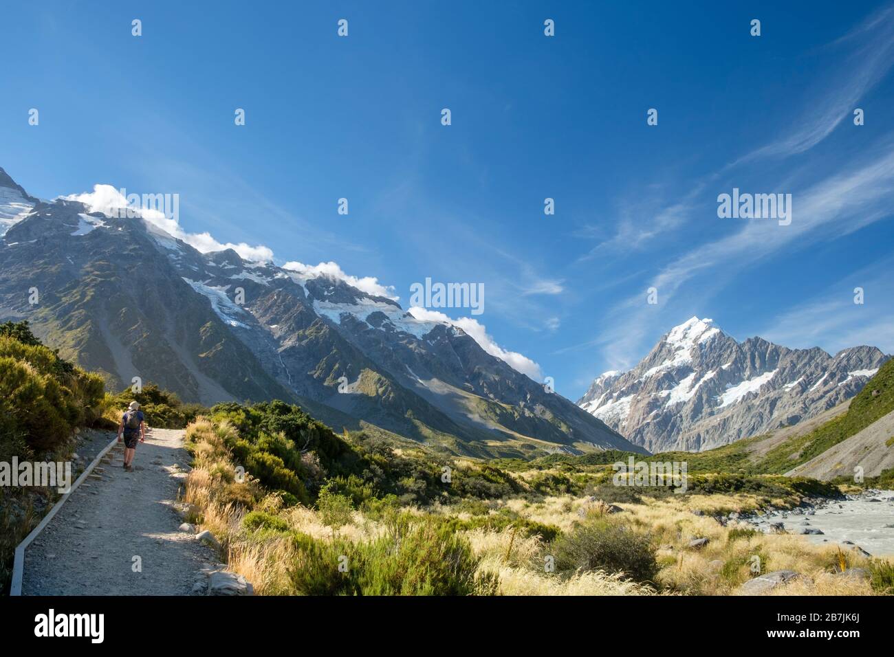 Uomo su sentiero con ghiacciai e montagne innevate, Hooker Track, Aoraki/Mount Cook National Park, South Island, Nuova Zelanda Foto Stock