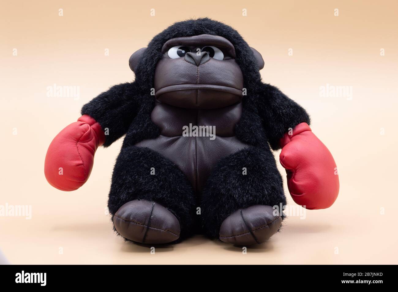 Boxer di gorilla giocattolo farcito con faccia arrabbiata che si posa su  uno sfondo giallo pallido. Concetto di boxe Foto stock - Alamy