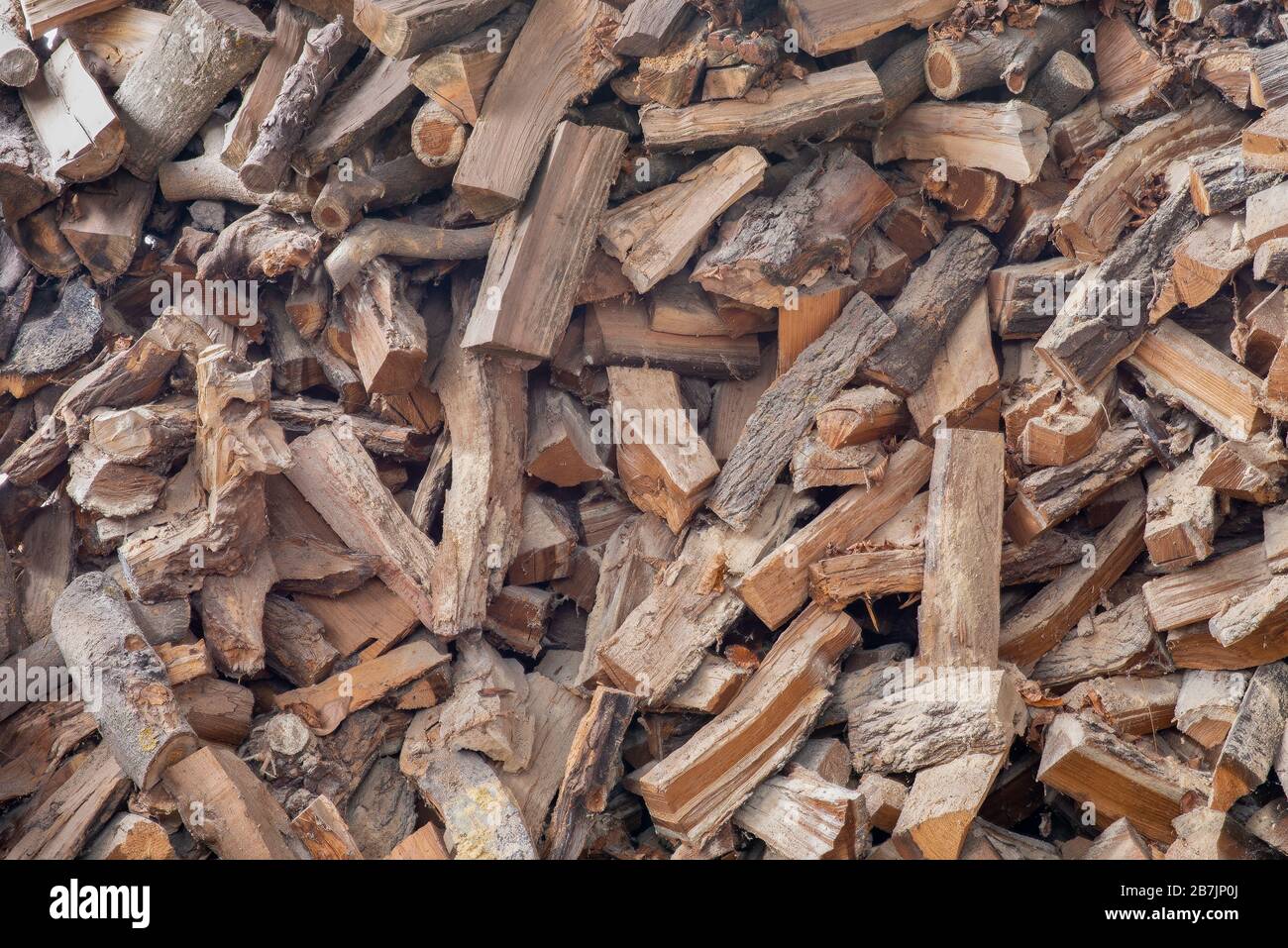 Legna da ardere tagliata su una pila. Sfondo di tronchi di legna da ardere tagliata a secco in un mucchio. Texture, carta da parati. Foto Stock