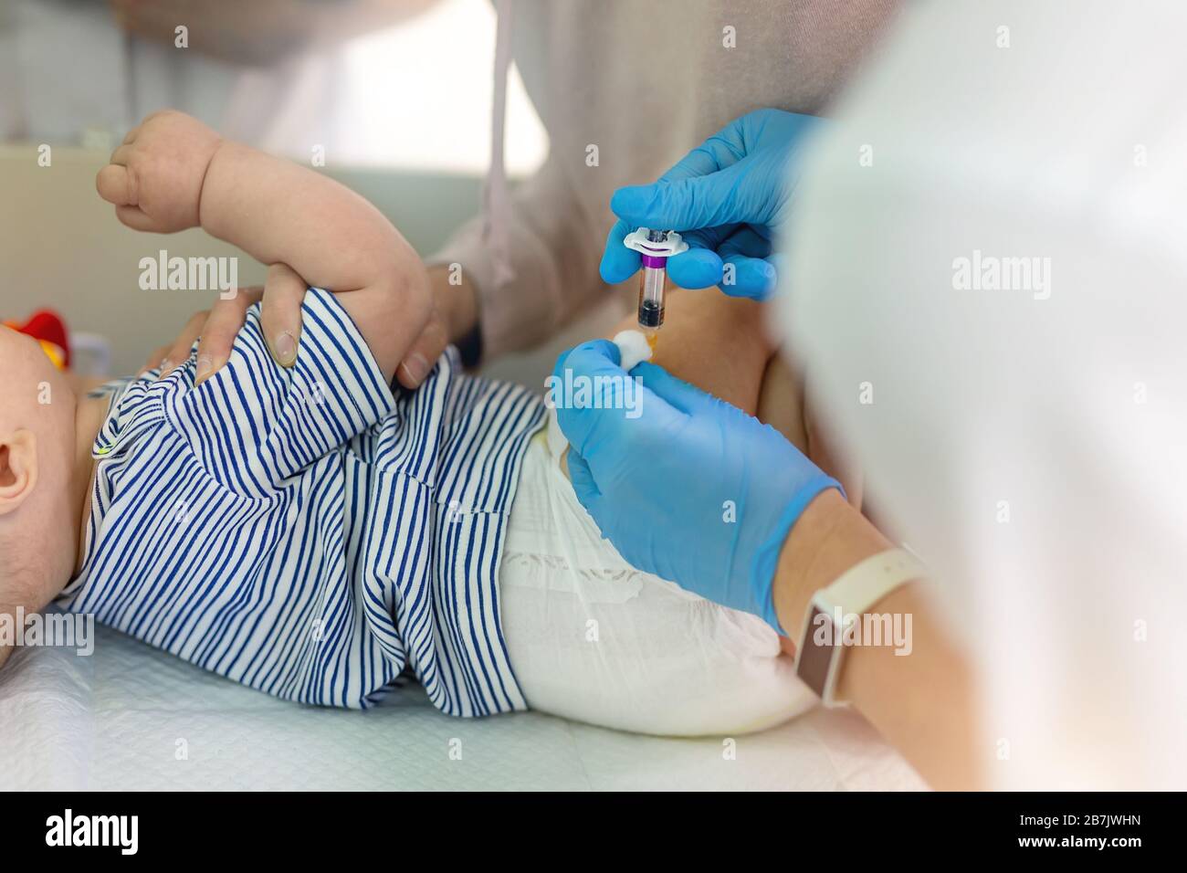 Infermiere che fa infante vaccinazione intramuscolare di routine contro la malattia e l'infezione da virus. Il medico nei guanti di gomma fa la siringa di iniezione nel babby Foto Stock