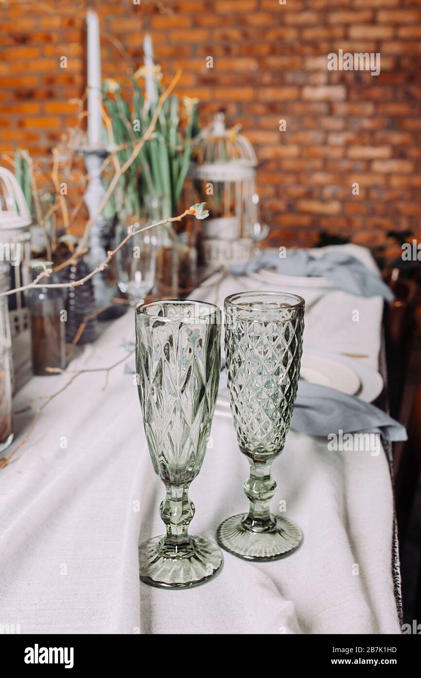 Due bicchieri di bevande verdi su un tavolo da pranzo ecologico per una data romantica. Tavolo in un misterioso stile primaverile con piante vive e branche Foto Stock