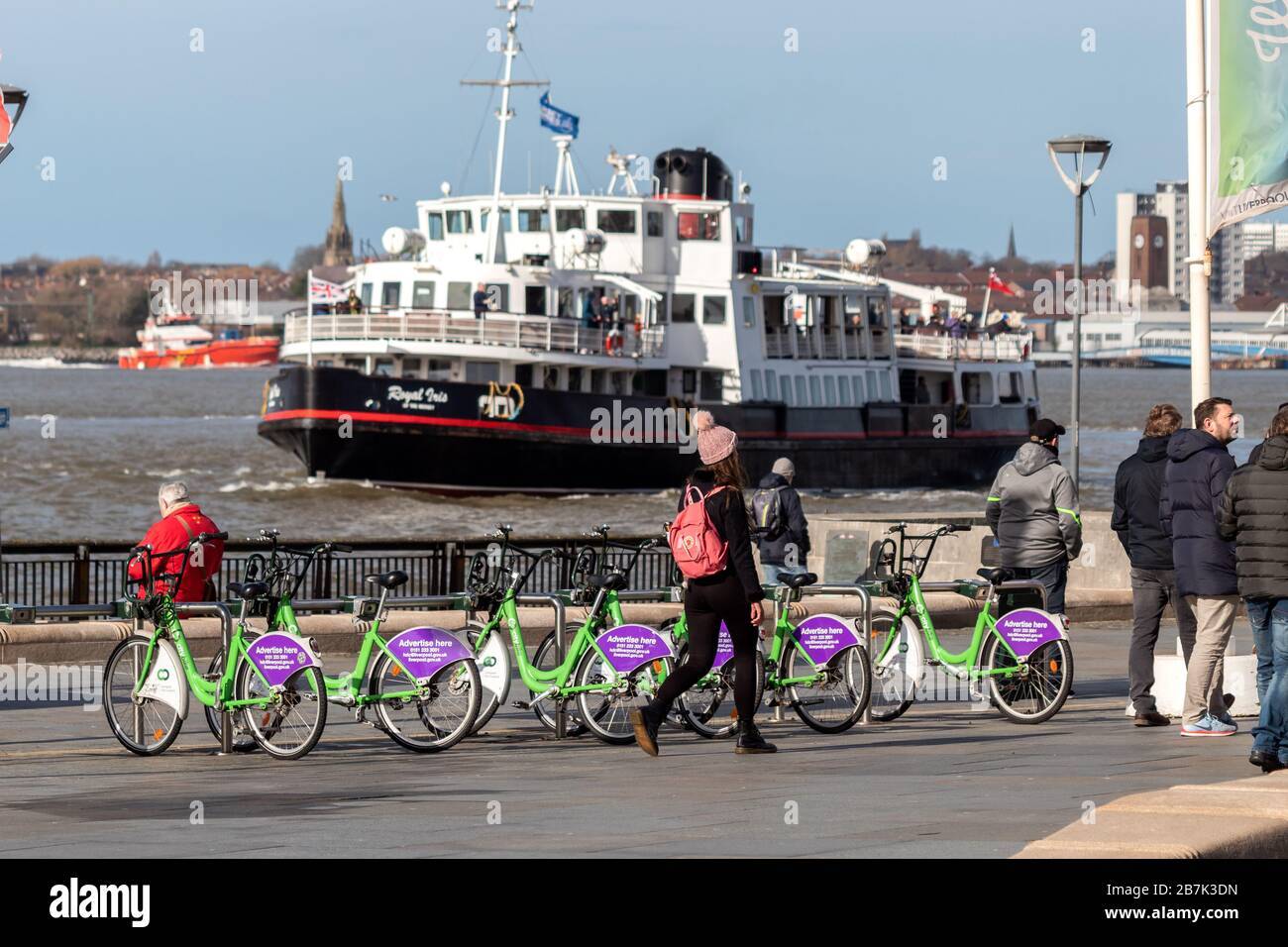 Persone sul lungomare di Liverpool, Mersey traghetto 'Royal Iris' sullo sfondo. Foto Stock