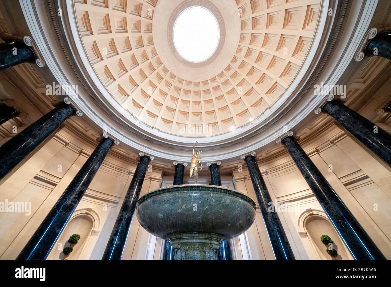 National Gallery of Art Rotunda Washington DC // WASHINGTON, DC, Stati Uniti — la grande rotonda della National Gallery of Art di Washington DC, mostra l'architettura neoclassica con la sua imponente cupola, il lucernario e le colonne corinzie. Una fontana centrale aggiunge un elemento dinamico allo spazio circolare, che funge da ingresso principale e punto focale del museo. Il design della rotonda, caratterizzato da un layout simmetrico e proporzioni classiche, esemplifica la visione dell'architetto John Russell Pope. Foto Stock
