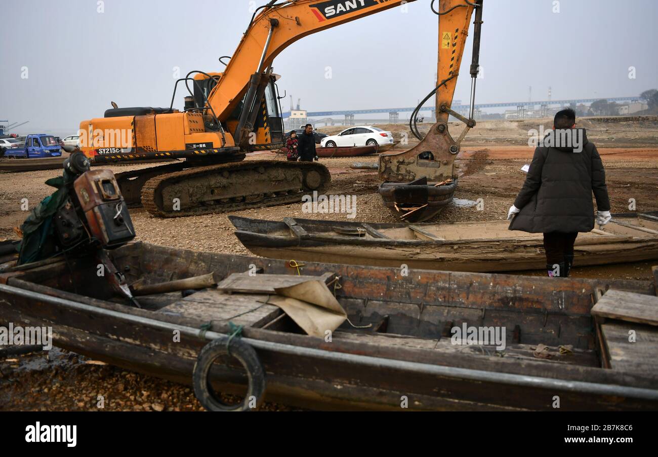 Un lavoratore guarda una barca da pesca che viene smantellata vicino al lago Dongting nella città di Yueyang, nella provincia di Hunan della Cina centrale, il 30 dicembre 2019. Un pesce di 10 anni Foto Stock