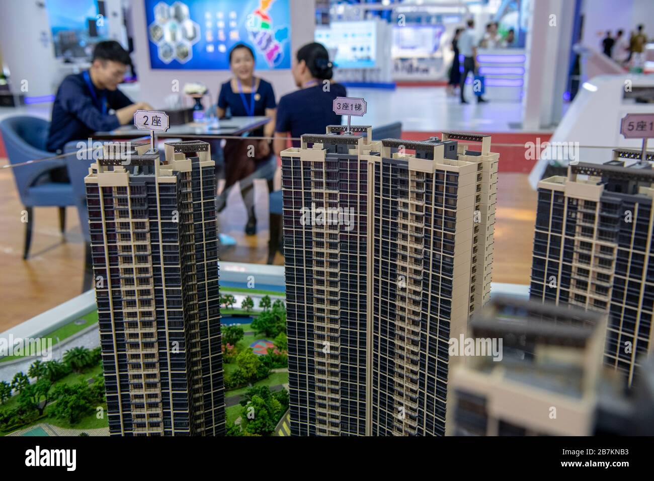 Foto creativa: In questa foto non localizzata, i clienti osservano modelli di edifici e appartamenti, considerando quale sia la casa giusta per loro, in un Foto Stock